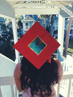 a woman wearing a red graduation cap with a picture on it