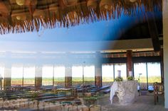 the inside of a building with tables and chairs in front of large windows that look out onto an open field