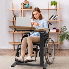 a woman sitting in a wheel chair using a laptop on her lap top computer desk