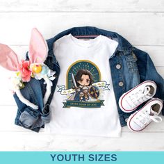 Introducing our "Saint Joan of Arc" Youth T-Shirt, a bold and inspiring gift for Catholic kids. This shirt features a striking depiction of Saint Joan of Arc, the courageous patron saint of France, making it a perfect gift for confirmations, first communions, and other special occasions. Crafted from soft, high-quality fabric, this t-shirt ensures comfort and durability for everyday wear. The vibrant design celebrates Saint Joan's bravery and faith, inspiring young girls to embody her spirit of Saint Joan Of Arc, Jeanne D'arc, St Joan, Catholic Kids, First Communion Gifts, Joan Of Arc, Communion Gifts, Patron Saints, First Communion