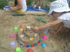 two children playing in the sand with toys