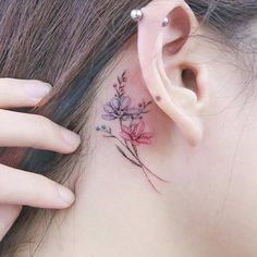 a close up of a person's ear with flowers on it