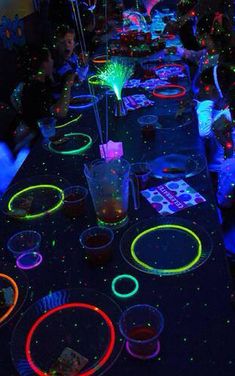 a long table covered in neon colored plates and cups