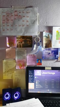 a laptop computer sitting on top of a desk next to a keyboard and mouse with sticky notes all over it