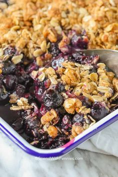 blueberry crisp in a baking dish with a spoon