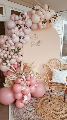 a room with balloons and flowers on the wall, chairs and rugs in front of it