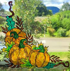 a stained glass window with pumpkins and leaves on it