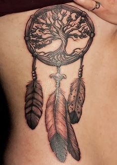 a tattoo on the back of a woman's shoulder with an arrow and tree