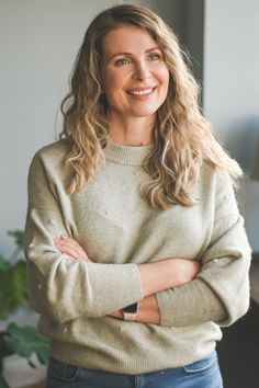 a smiling woman with her arms crossed