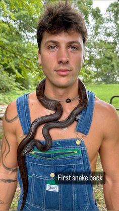 a man in overalls with a snake on his chest