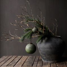 a potted plant sitting on top of a wooden table next to an ornament