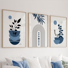 three framed art pieces hang on the wall above a white couch in a living room