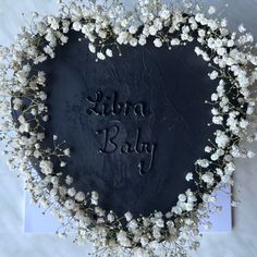 Black coloured cake shaped as a heart, with baby’s breath flowers along the edge and libra baby written on the top Witch Cake Ideas, Libra Birthday Cake, Witches Brunch, Witch Cakes, Witch Font, Solar Return, Libra Birthday