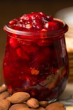 a jar filled with jelly and almonds on top of a table