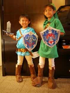 two children dressed up in costumes standing next to each other holding swords and shieldes