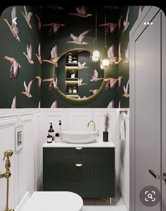 a bathroom with green and white wallpaper has a sink, mirror, toilet and bathtub