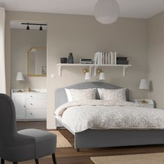 a bedroom with a bed, chair and bookshelf