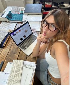 a woman sitting at a desk with a laptop computer