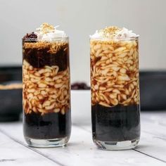 two glasses filled with food sitting on top of a table