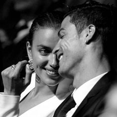 a black and white photo of a man and woman smiling at each other with their eyes closed