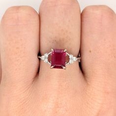 This beautiful ring features an emerald-cut ruby with a triad of natural earth-mined diamonds on both sides, all set in solid 14K white gold. This ring can be a lovely July birthstone gift for your loved ones! This ring is made with solid 14K Gold and naturally Earth-mined SI / G-H diamonds. If you're interested in purchasing this setting with a different center stone please message us! Elegant Gia Certified Emerald Cut Ruby Ring, Asscher Cut Ruby And Diamond Ring, Asscher Cut Diamond Ruby Ring With Prong Setting, Gia Certified Emerald Cut Ruby Ring In White Gold, Gia Certified Ruby Jewelry With Baguette Cut, Gia Certified Baguette Cut Ruby Jewelry, Fine Jewelry Ruby Ring With Radiant Cut Diamond, Red Emerald Cut Diamond Rings, White Gold Ruby Ring With Princess Cut