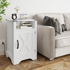 a living room with a couch and a white cabinet next to a potted plant