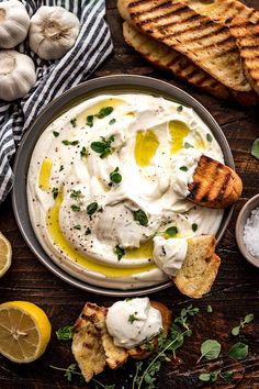 an image of a bowl of hummus with bread and garlic