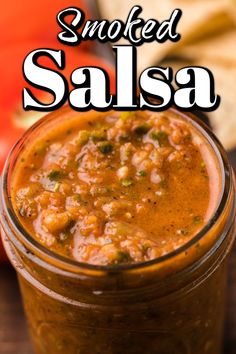 a jar filled with salsa sitting on top of a wooden table