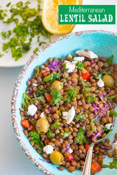 a blue bowl filled with lentula salad next to a lemon slice and parsley