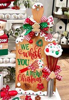 a wooden sign that says we wish you a merry christmas with some decorations around it