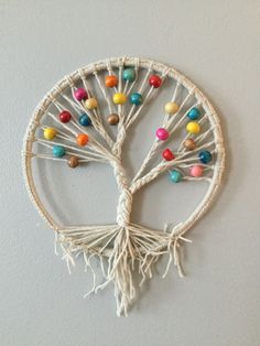 a wall hanging made out of yarn with candy beads on the tree of life design