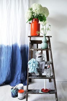 a wooden ladder with flowers and other items on it