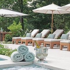 towels and glasses are sitting on the edge of an outdoor jacuzzi