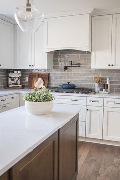 a kitchen with white cabinets and an island