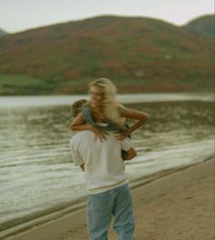 a man carrying a woman on the beach