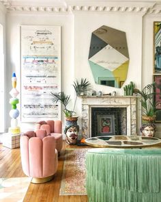 a living room filled with lots of furniture and art on the wall above it's fireplace