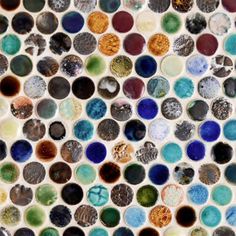 a close up view of a mosaic tile wall with many different colors and shapes on it