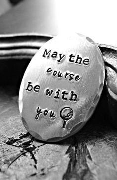 a metal disc with the words may the course be with you on it sitting on top of a table