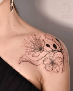 a woman's shoulder with a flower tattoo on her left shoulder and the back of her neck