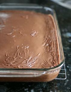 a chocolate cake in a glass dish on a counter