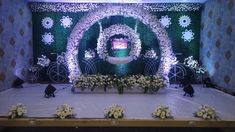 the stage is decorated with white flowers and greenery