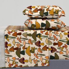 three sheets with colorful designs on them stacked on top of each other in front of a gray wall