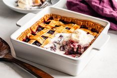 a close up of a pie in a pan with ice cream and berries on top