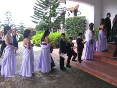 a group of people standing on top of a brick floor next to eachother