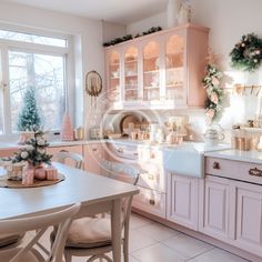 the kitchen is decorated for christmas with pink and white decor, such as wreaths