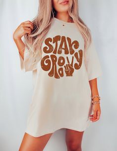 "PLEASE NOTE This is a standard unisex size Comfort Colors Tee. For an oversized tee, please size up. If you are looking for an oversized \"T-shirt Dress\" look, we recommend sizing up 2 sizes. Please review the size chart to ensure you receive the fit you want.---Unisex Crew Neck----- *Product Description * 100% ring spun cotton soft washed garment dyed fabric double needle collar twill taped neck and shoulders double needle armhole, sleeve and bottom hems as with all pigment dyed shirts colors White Hippie Tops With Letter Print, White Crew Neck Hippie T-shirt, White Short Sleeve Groovy Tops, White Groovy Short Sleeve Tops, Groovy White Short Sleeve Tops, White Hippie Crew Neck T-shirt, Hippie Oversized Graphic Print Tops, Groovy Relaxed Fit Crew Neck Top, Groovy Short Sleeve T-shirt With Letter Print