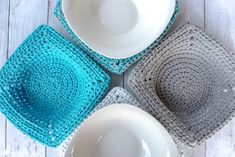 four crocheted placemats and bowls on a white wooden table