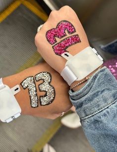 two girls with tattoos on their arms and one has the number thirteen painted on her arm