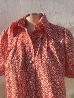 "Orange and white lovely buttoned shirt from 1960 Sturdy thick fabric in straight line, loose fit, closes with cute round white buttons in the shape of a ball ⚽️ Pointed collars, short sleeves with revers and lovely daisy/floral pattern all the way around Authentic 1960s piece for all the 60's lovers... ‼️Be aware - only one piece is available----- 🌀MEASUREMENTS: (taken while laying flat and un-stretched) *BUST : (pit to pit) 52 cm / 20.5\" *WAIST: 54 cm / 21.2\" *LENGTH - Measured from shoulde Orange Buttoned Blouse For Spring, Orange Button Blouse For Spring, Summer Shirt With Covered Buttons And Collared, Spring Orange Shirt With Button Closure, Red Retro Print Shirt For Spring, Orange Shirt With Button Closure For Spring, Retro Spring Shirt With Buttons, Summer Shirt With Peter Pan Collar And Buttons, Classic Orange Tops With Buttons