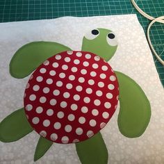 a close up of a piece of fabric with a turtle on it and white polka dots